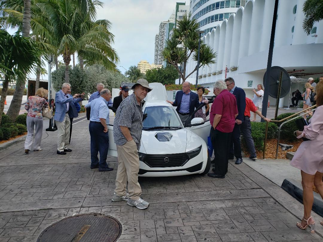 Attendees examining a demonstration vehicle outside a Miami Beach hotel