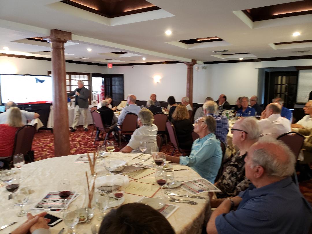Attendees turning toward a projection screen during an afternoon presentation