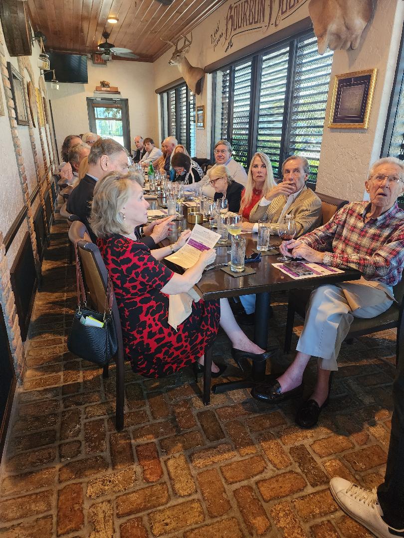 Guests seated along a brick-walled dining room during a presentation