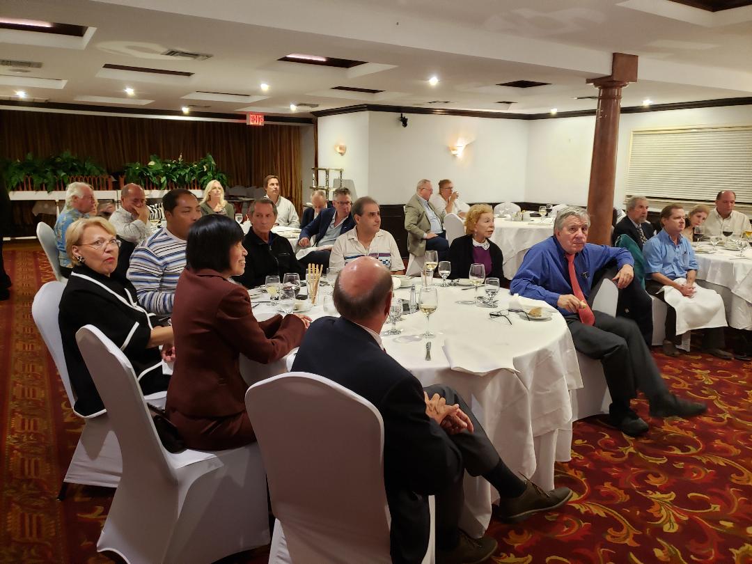 Guests at round tables watching a presentation in a banquet room