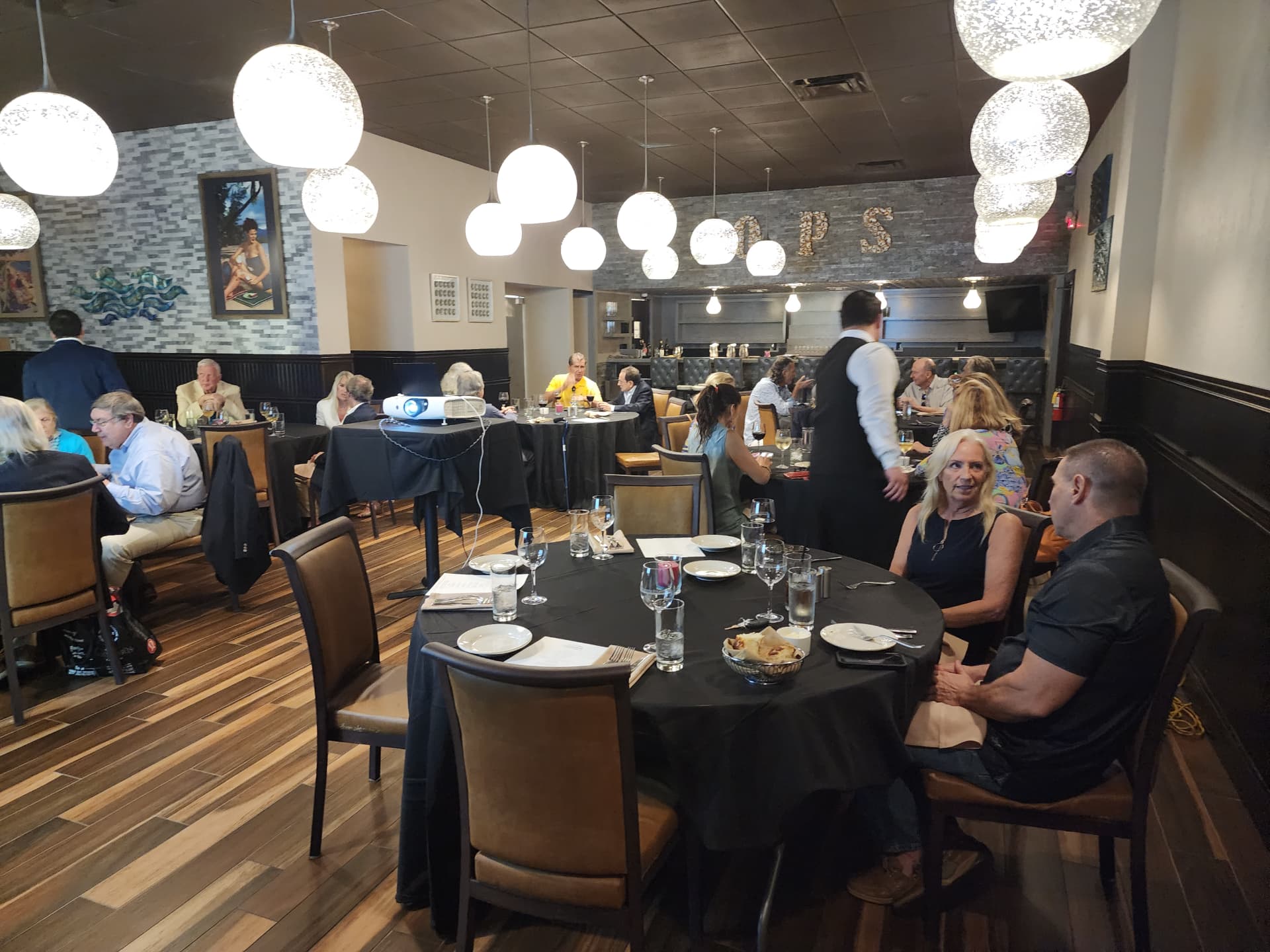 A private dining room set for an investor luncheon with projector in place