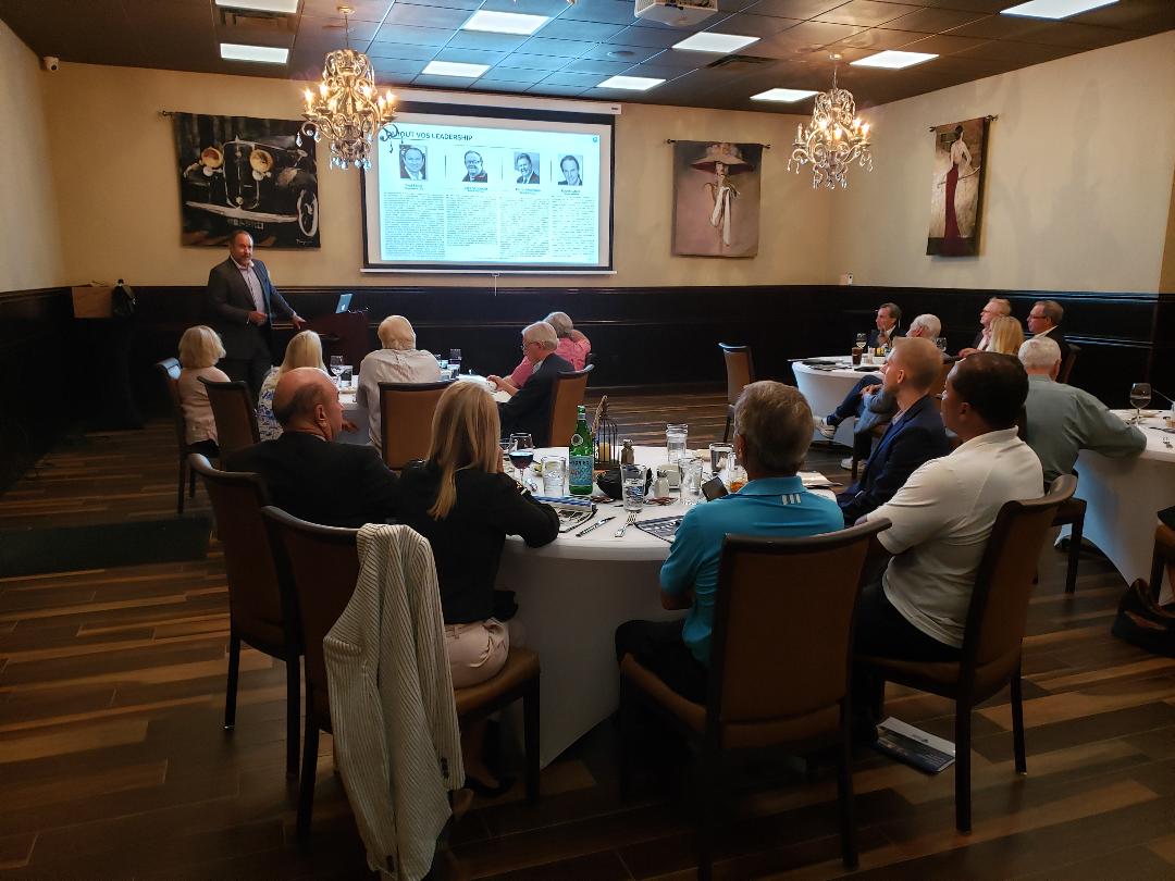 A leadership slide projected for guests seated at round tables