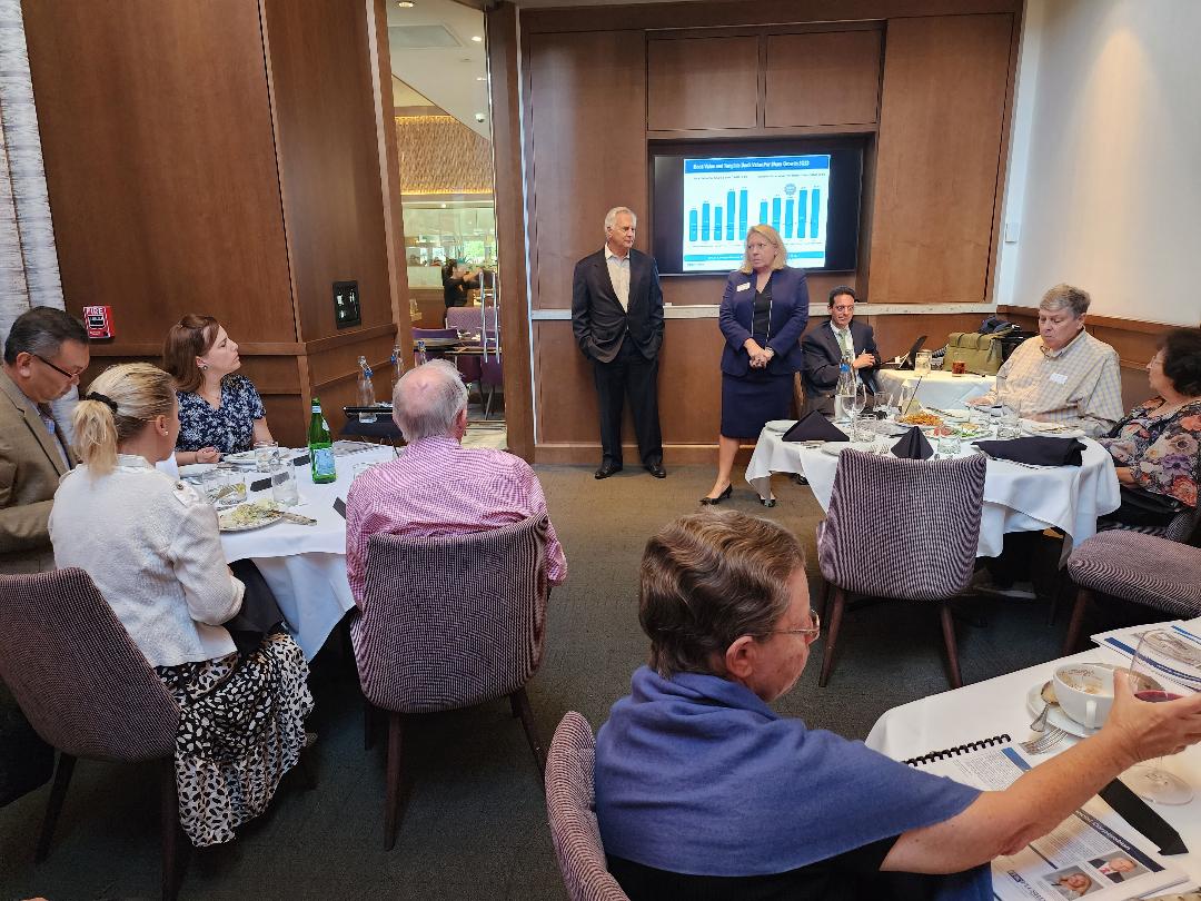 Two executives presenting book-value growth figures to seated guests