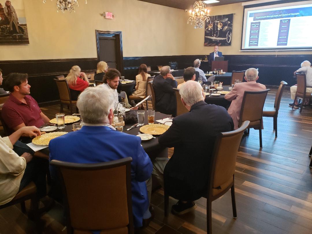 Attendees viewing a management and board of directors slide during lunch