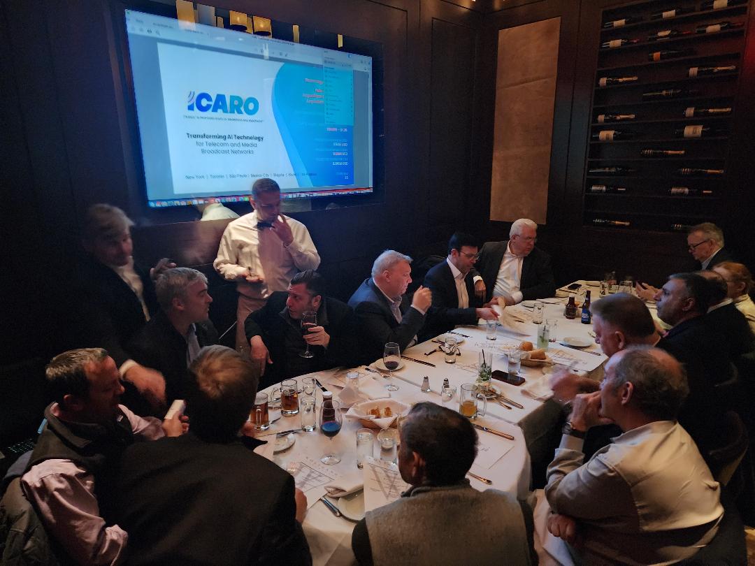 Investors seated around a round table in a wine room watching an AI technology presentation