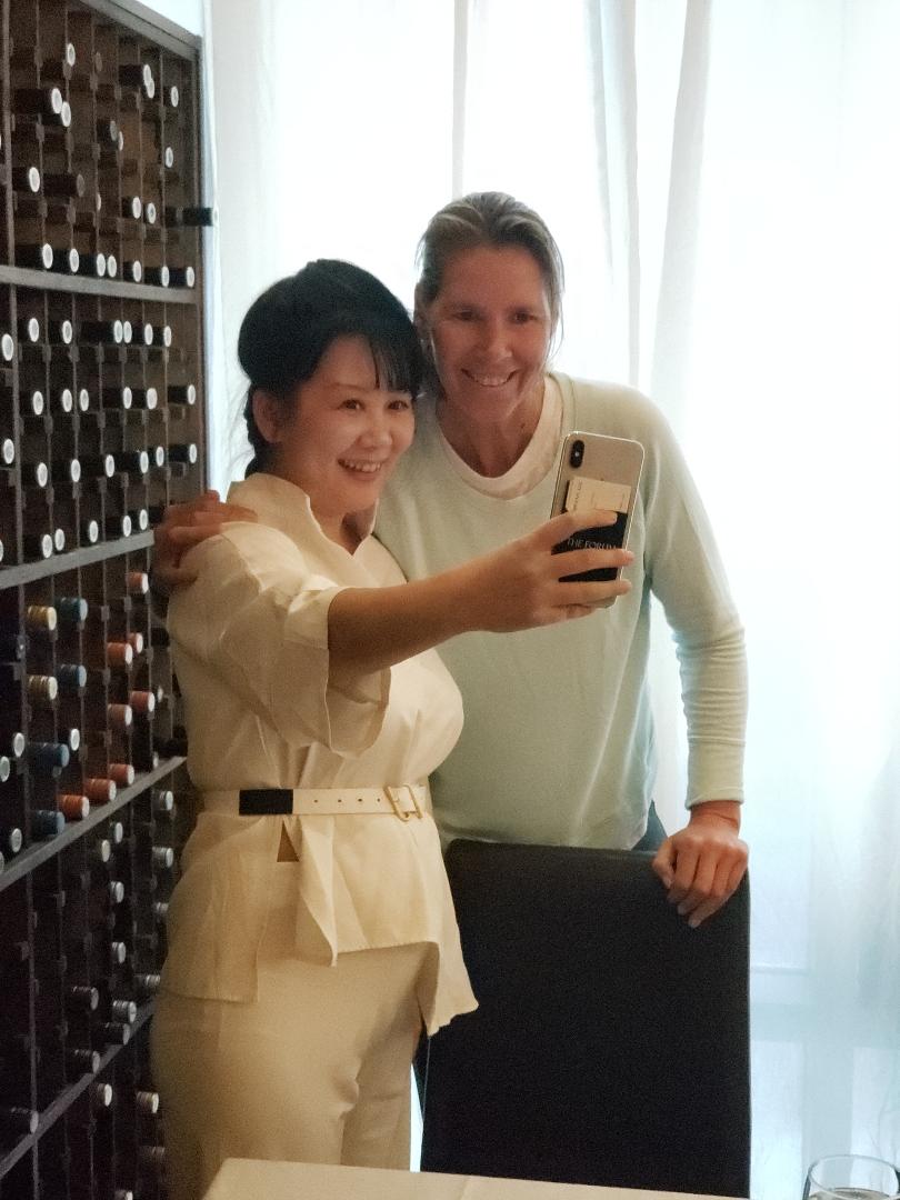 An attendee taking a photograph with a former professional tennis player