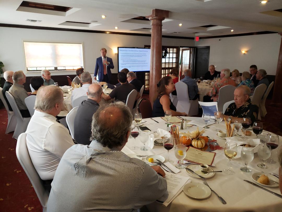 An executive presenting to a room of investors at a luncheon meeting