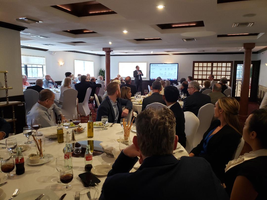 A full room of attendees watching a company presentation after the site visit